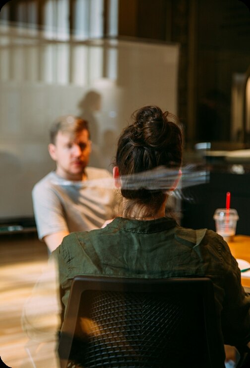 Two person chatting over coffee at a table