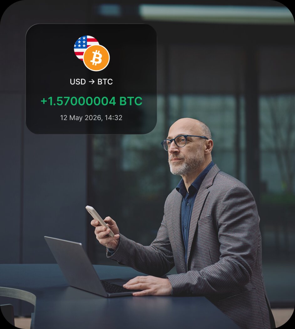 A professional reviewing a USD to BTC transaction on a laptop, with the transaction detail card overlaid